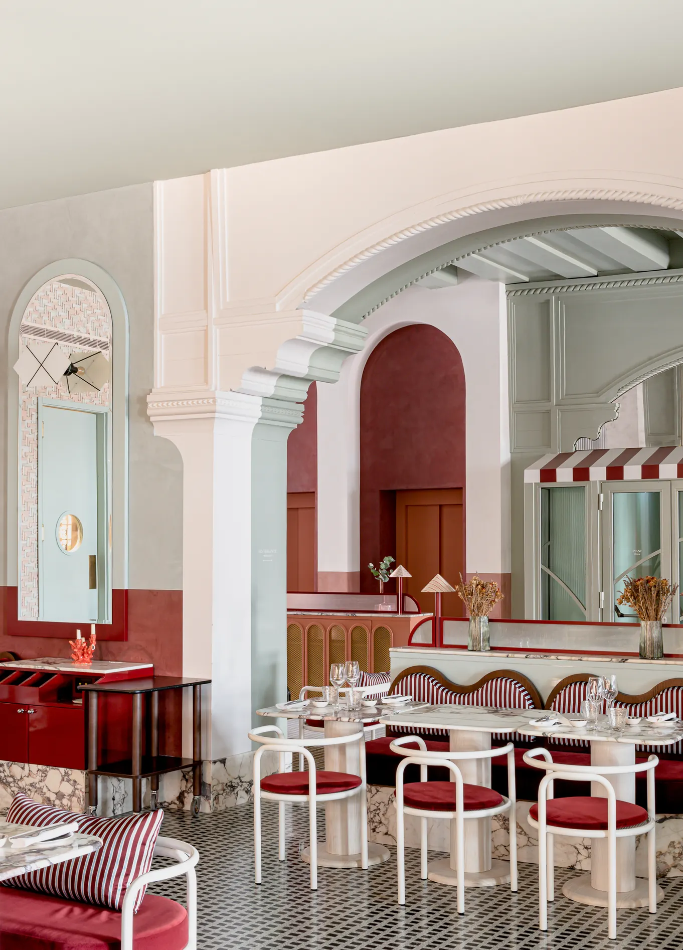 Bright dining room with white arches and red chairs at Adriatica fine dining restaurant, Venice