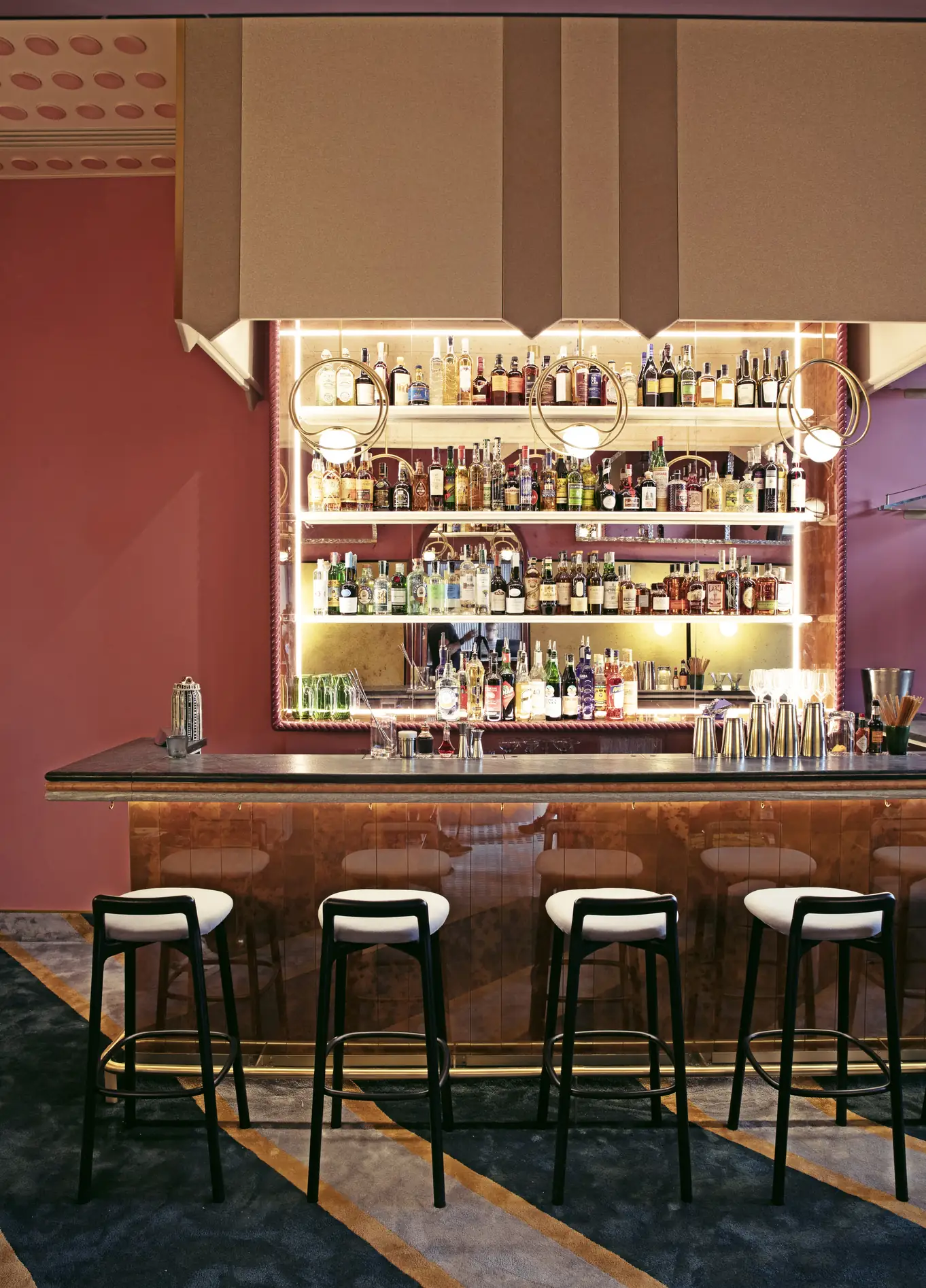 Bar with bottle shelves and red lighting at Experimental Cocktail Club, Venice