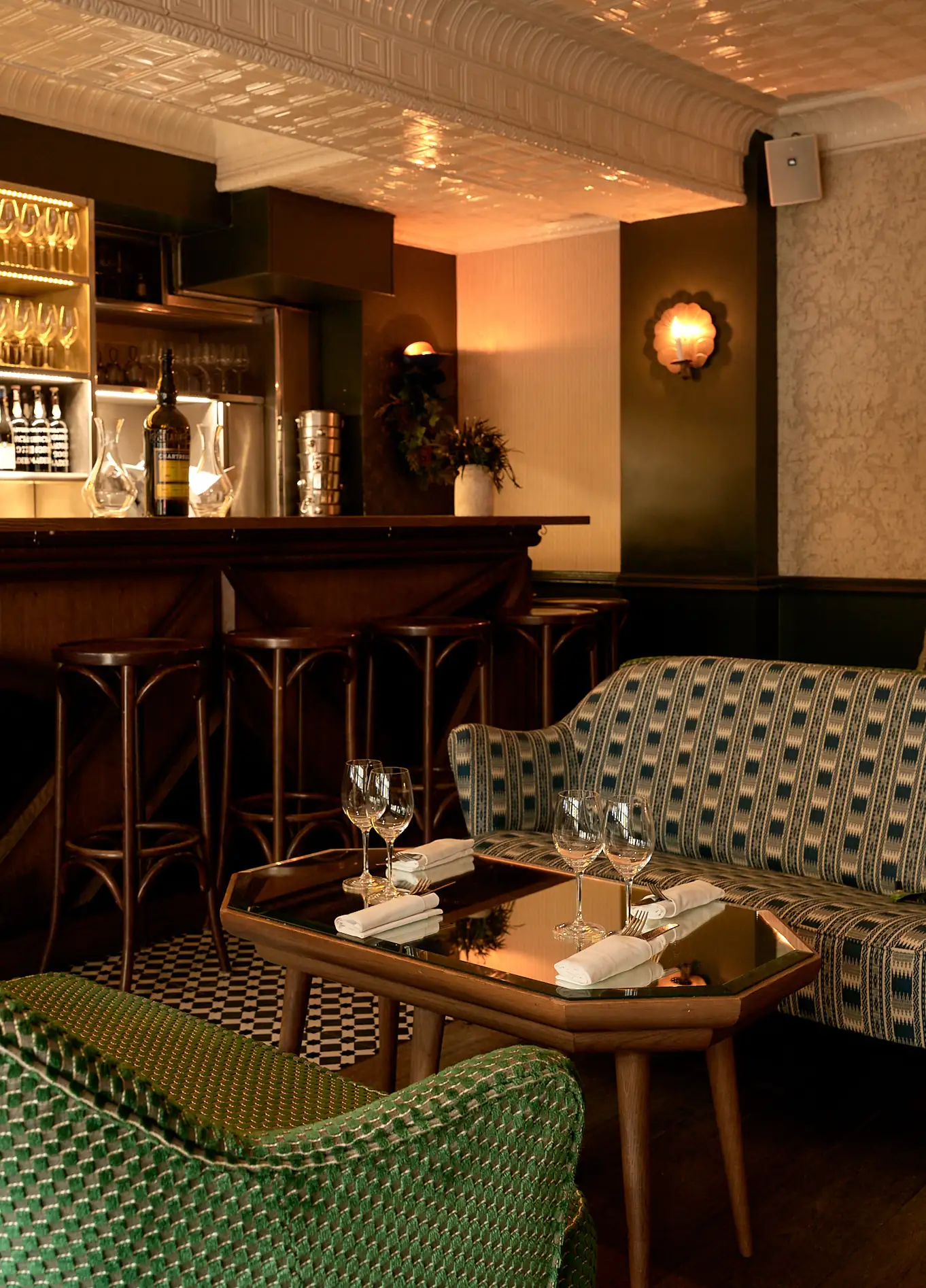 Warm interior of La Compagnie Wine Bar featuring a bar counter, high stools, and a cozy lounge area with sofas.