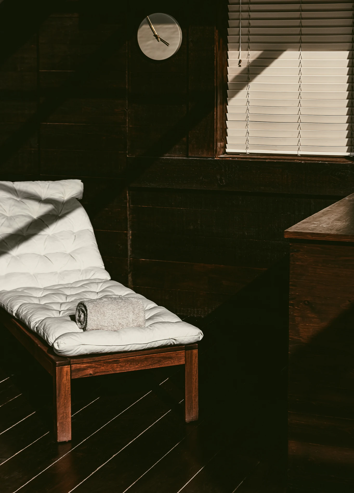 A white lounge chair in a room with dark walls and a cozy atmosphere at the Experimental Chalet Verbier hotel.