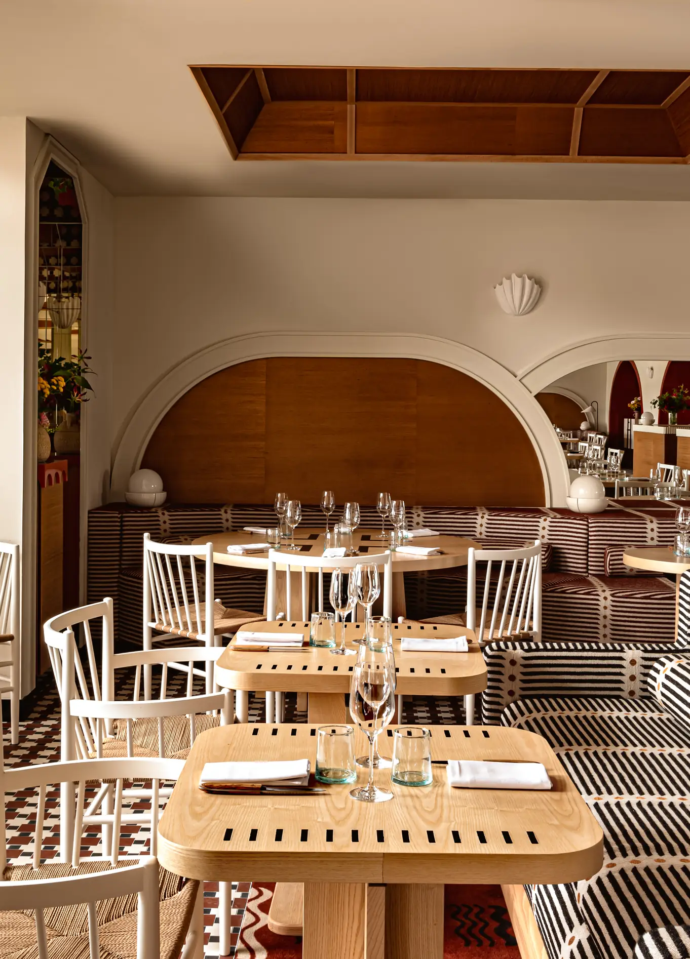 Refined interior of the Regina Experimental hotel restaurant, featuring wooden tables and comfortable seating in a warm atmosphere.