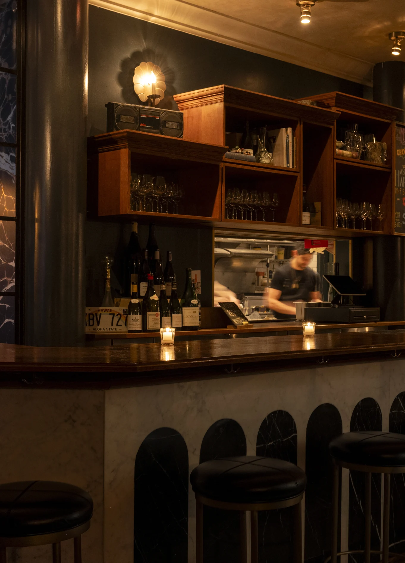 Elegant bar counter with wooden shelves and dim lighting at La Compagnie Wine Bar.