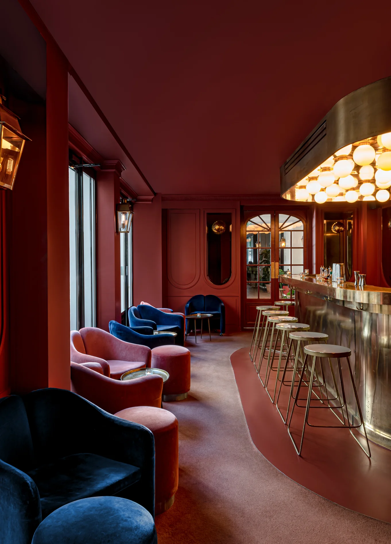 Red velvet lounge with dim lighting at The Shell cocktail bar, Grands Boulevards Experimental, Paris